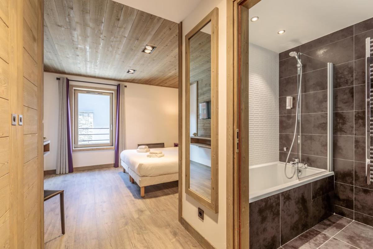 une salle de bain avec un lit, une baignoire et une douche dans l'établissement Victoria Lodge, Friendly Hotel, à Val dʼIsère 53 autres photos
