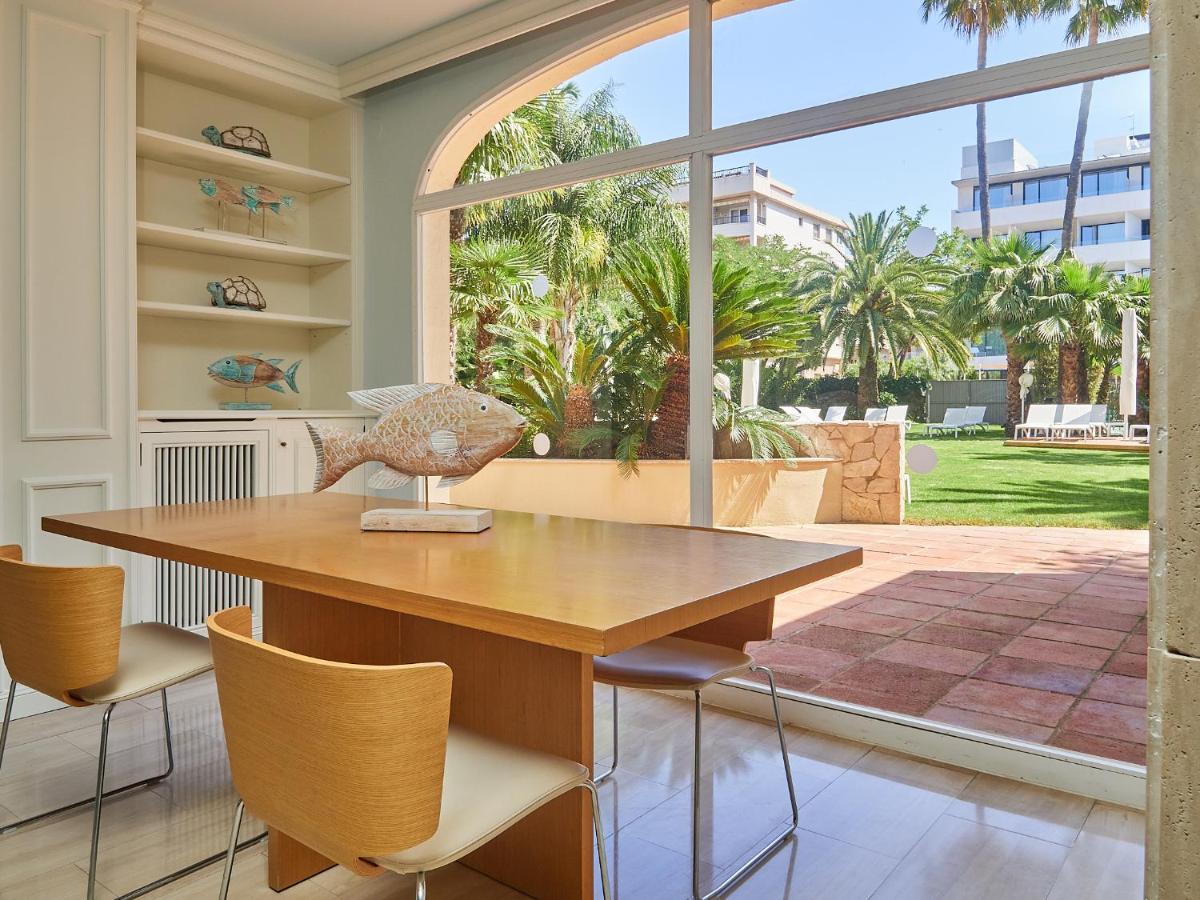 Un comedor con mesa y sillas y una gran ventana. en Mònica Hotel, en Cambrils