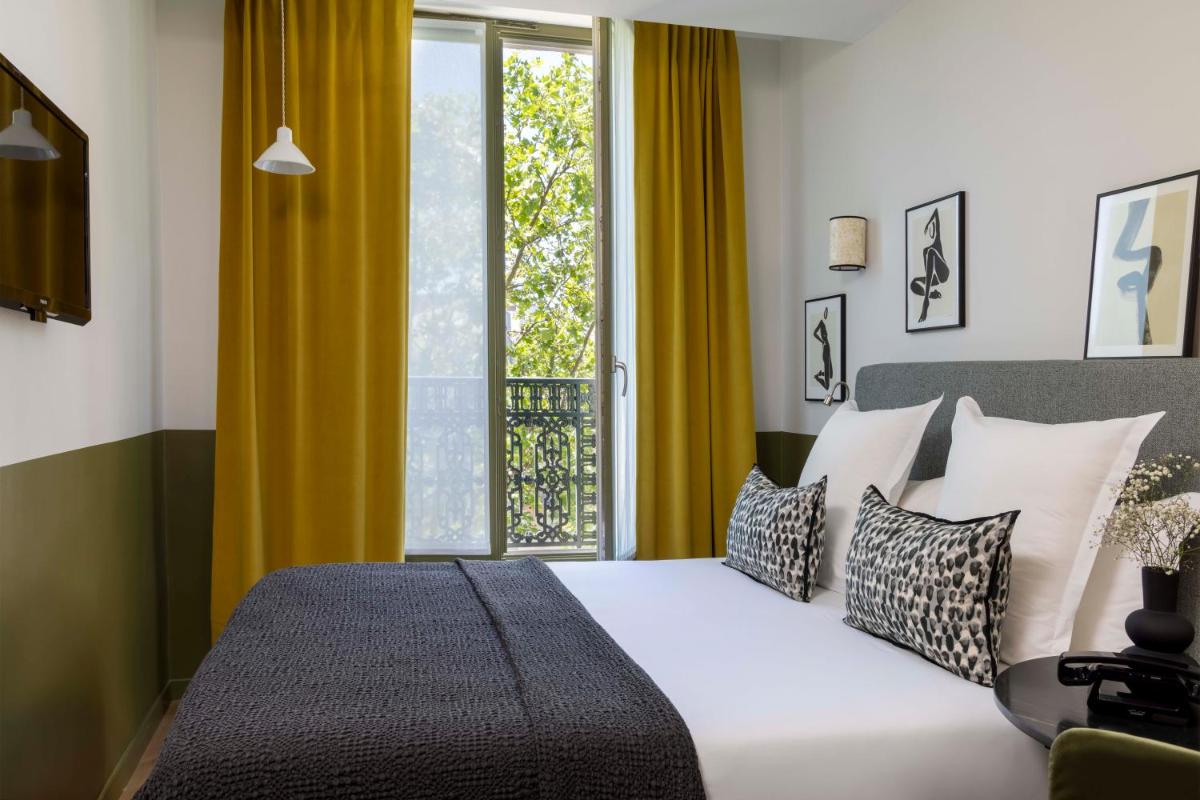 une chambre avec un lit et une grande fenêtre dans l'établissement Le Petit Beaumarchais Hotel & Spa, à Paris 40 autres photos