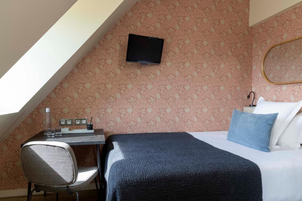 Un ou plusieurs lits dans un hébergement de l'établissement Le Petit Beaumarchais Hotel & Spa