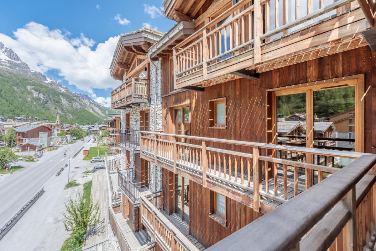 un balcon d'un pavillon donnant sur une rue dans l'établissement Victoria Lodge, Friendly Hotel, à Val dʼIsère