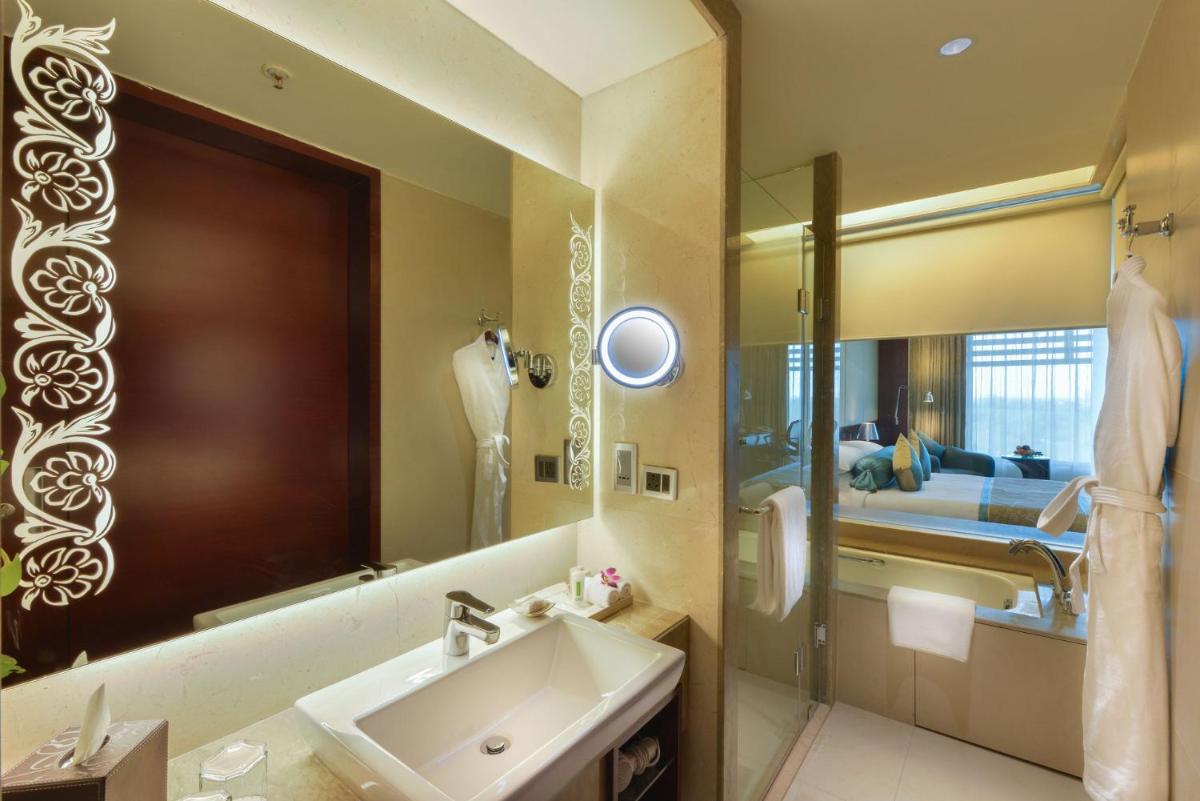 a bathroom with a sink and a large mirror at Crowne Plaza Ahmedabad City Centre by IHG in Ahmedabad