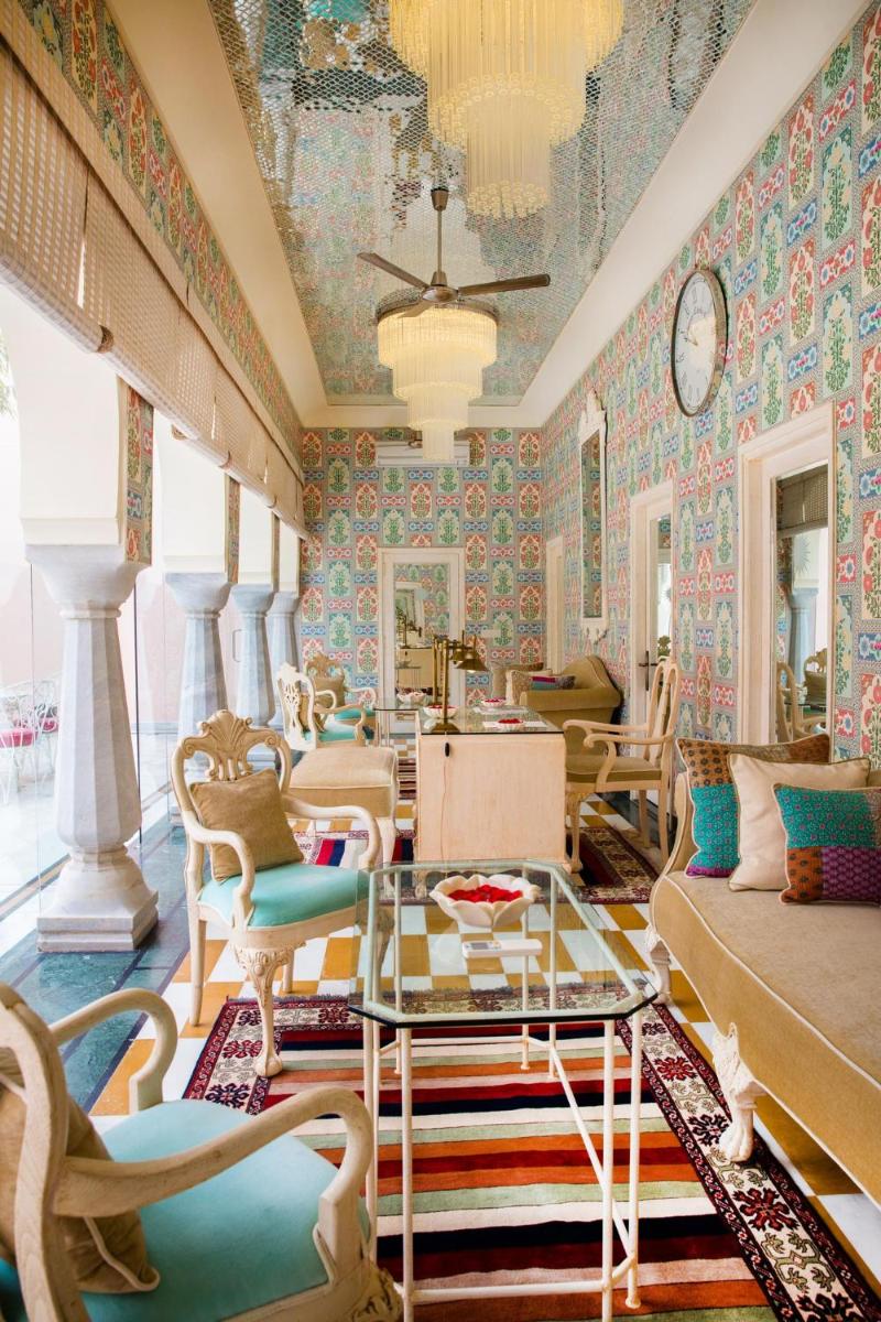 a living room with colorful wallpaper and a table and chairs at Rajmahal Palace RAAS in Jaipur