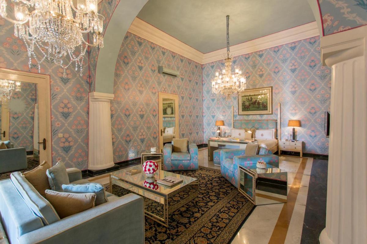 a living room with blue furniture and a chandelier at Rajmahal Palace RAAS in Jaipur
