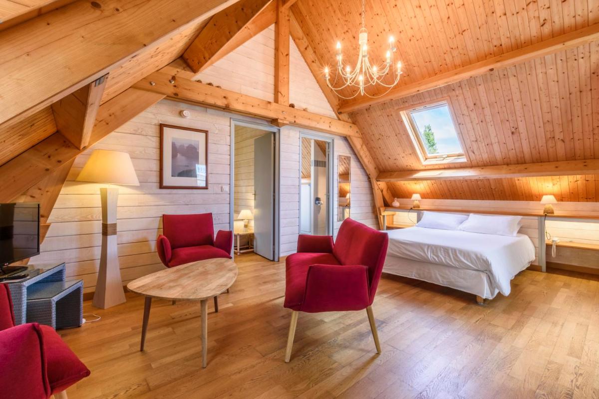- une chambre avec un lit et deux chaises rouges dans l'établissement La Désirade - Hôtel, Spa & Restaurant, à Bangor