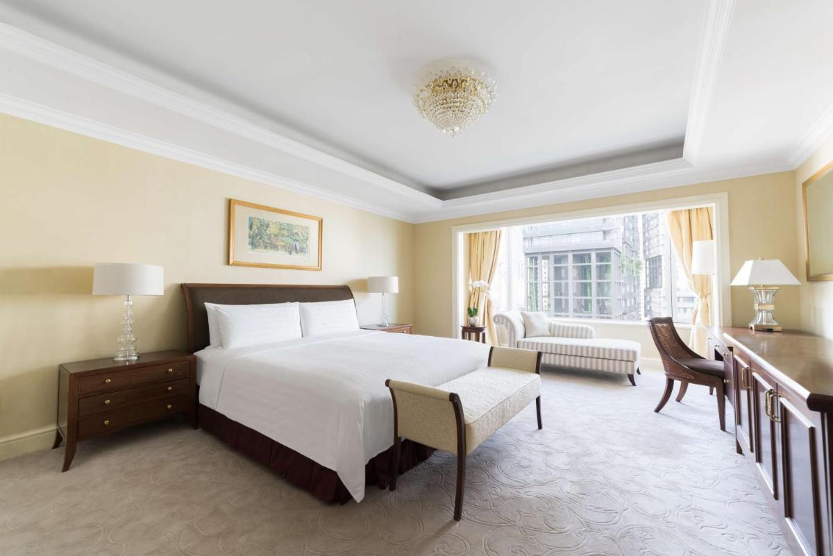 a bedroom with a large bed and a large window at Shangri-La Singapore in Singapore