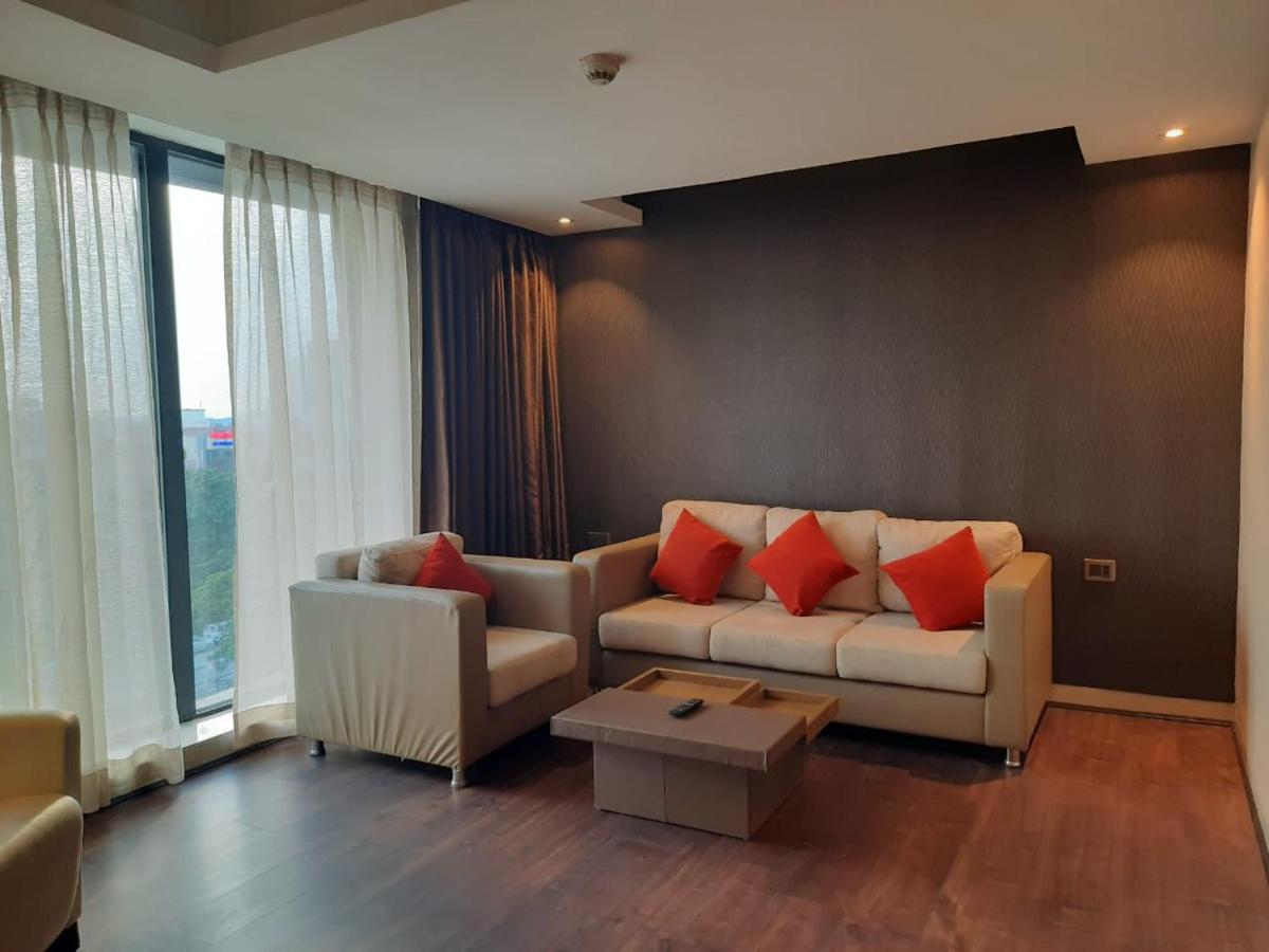 a living room with a white couch and red pillows at Holiday Inn Kolkata Airport by IHG in Kolkata