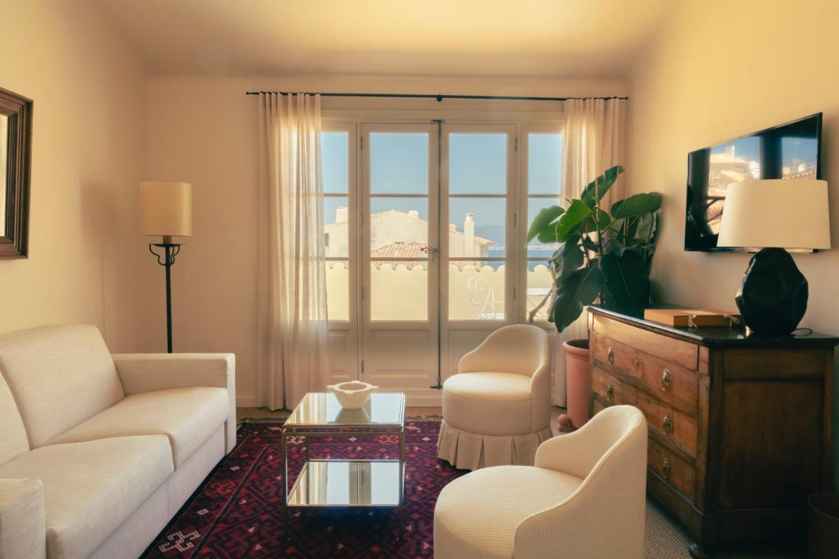 un salon avec un canapé, des chaises et une fenêtre dans l'établissement Hotel la Ponche, à Saint-Tropez