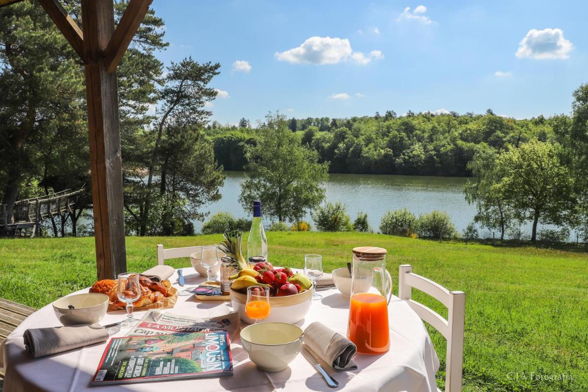 - une table avec de la nourriture et une vue sur le lac dans l'établissement Vacancéole - Le Domaine des Monédières, à Meyrignac-lʼÉglise