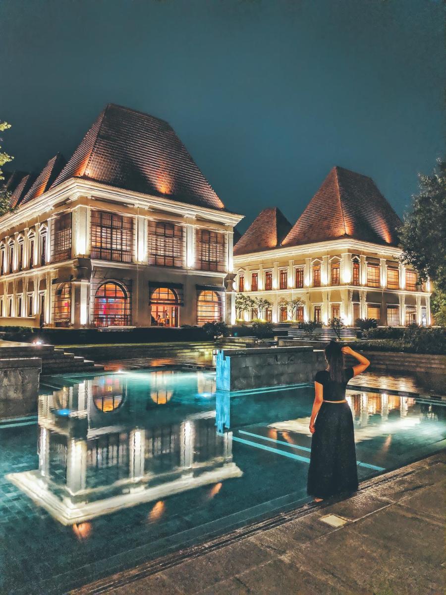 a woman standing in front of a large building at Grand Hyatt Goa in Panaji a woman standing in front of a large building at Grand Hyatt Goa in Panaji