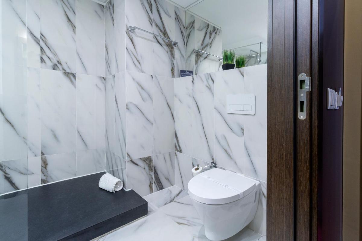 um banheiro branco com vaso sanitário e banheira em In Gold Hotel & Spa em Águeda