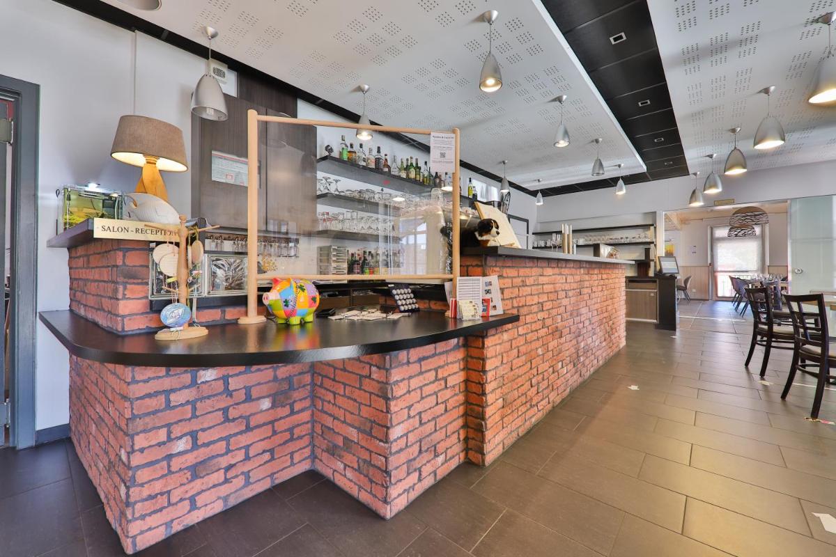 un bar dans un restaurant avec un mur de briques dans l'établissement Hôtel Restaurant et Spa Au Tilleul, à Labaroche
