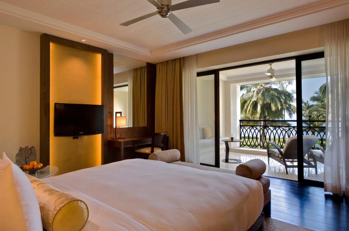 a bedroom with a large bed and a balcony at Grand Hyatt Goa in Panaji a bedroom with a large bed and a balcony at Grand Hyatt Goa in Panaji