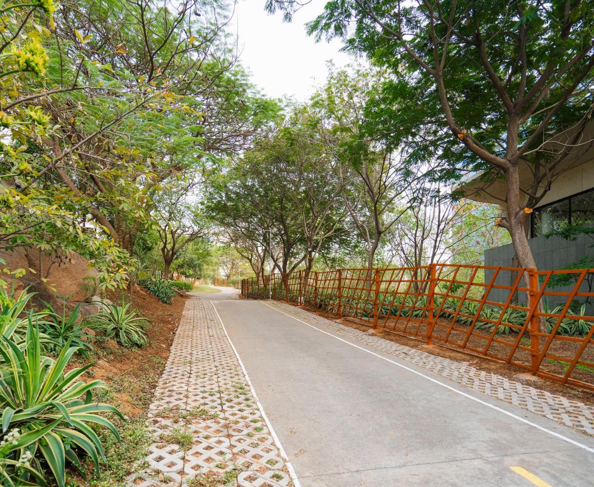 a road with an orange fence and trees at Hyatt Hyderabad Gachibowli in Hyderabad