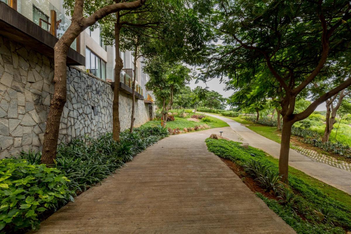 a path in a park next to a building at Hyatt Hyderabad Gachibowli in Hyderabad