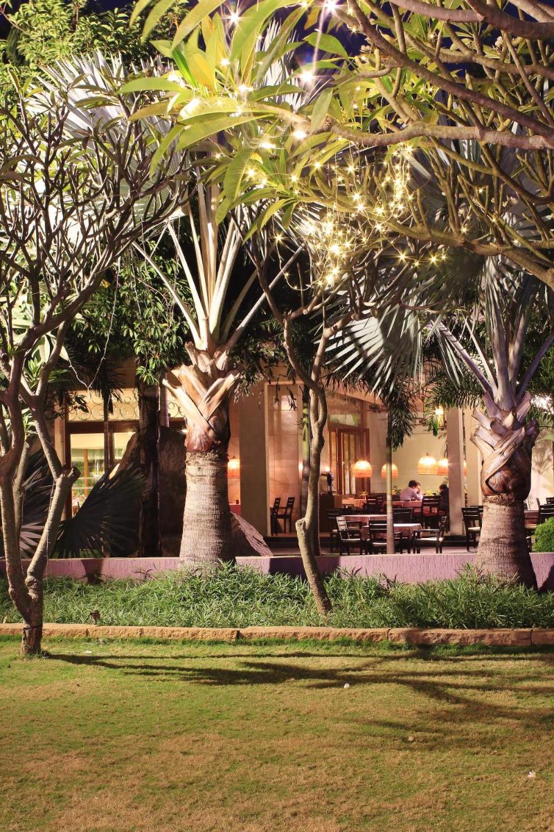 a group of trees in front of a building with lights at Hyatt Hyderabad Gachibowli in Hyderabad