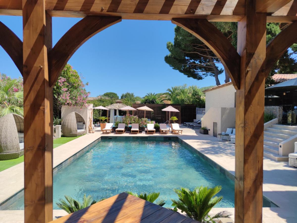 - une piscine avec une pergola en bois et une piscine dans l'établissement La Villa Dune, Hôtel & Spa, à Saint-Tropez