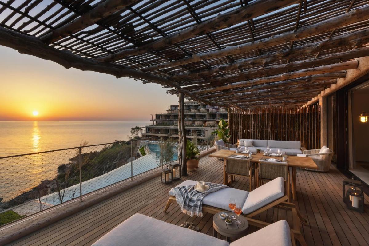 un balcón con vistas al océano al atardecer en Six Senses Ibiza, en Portinatx