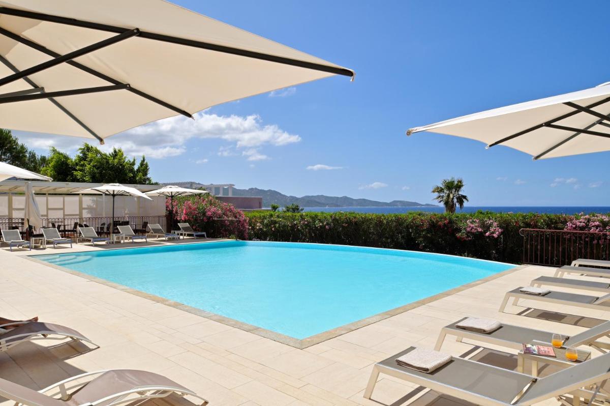 une piscine avec chaises et parasols dans l'établissement Hôtel Demeure Loredana, à Saint-Florent une piscine avec chaises et parasols dans l'établissement Hôtel Demeure Loredana, à Saint-Florent