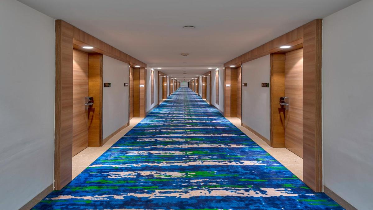 a corridor with a colorful carpet in a hotel hallway at Holiday Inn Gurugram Sector 90 by IHG in Gurgaon