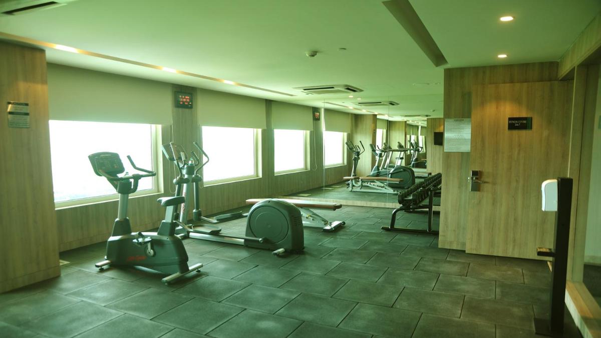 a gym with treadmills and ellipticals in a room at Holiday Inn Gurugram Sector 90 by IHG in Gurgaon