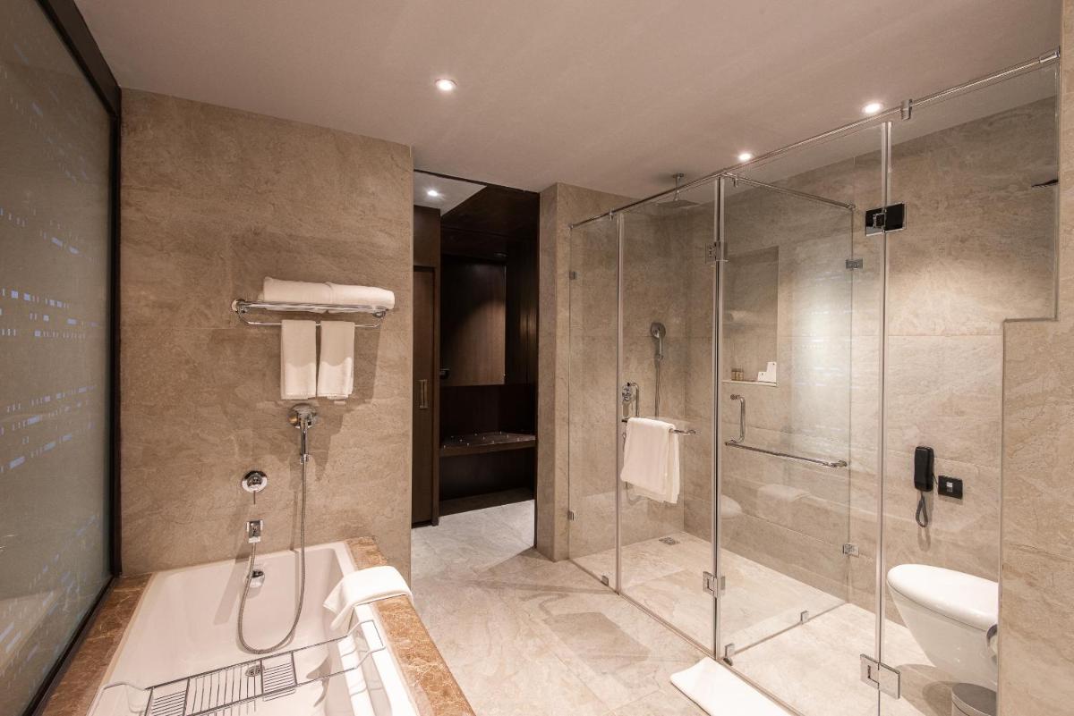 a bathroom with a shower and a bath tub at Grand Mercure Bengaluru at Gopalan Mall - An Accor Brand in Bengaluru a bathroom with a shower and a bath tub at Grand Mercure Bengaluru at Gopalan Mall - An Accor Brand in Bengaluru