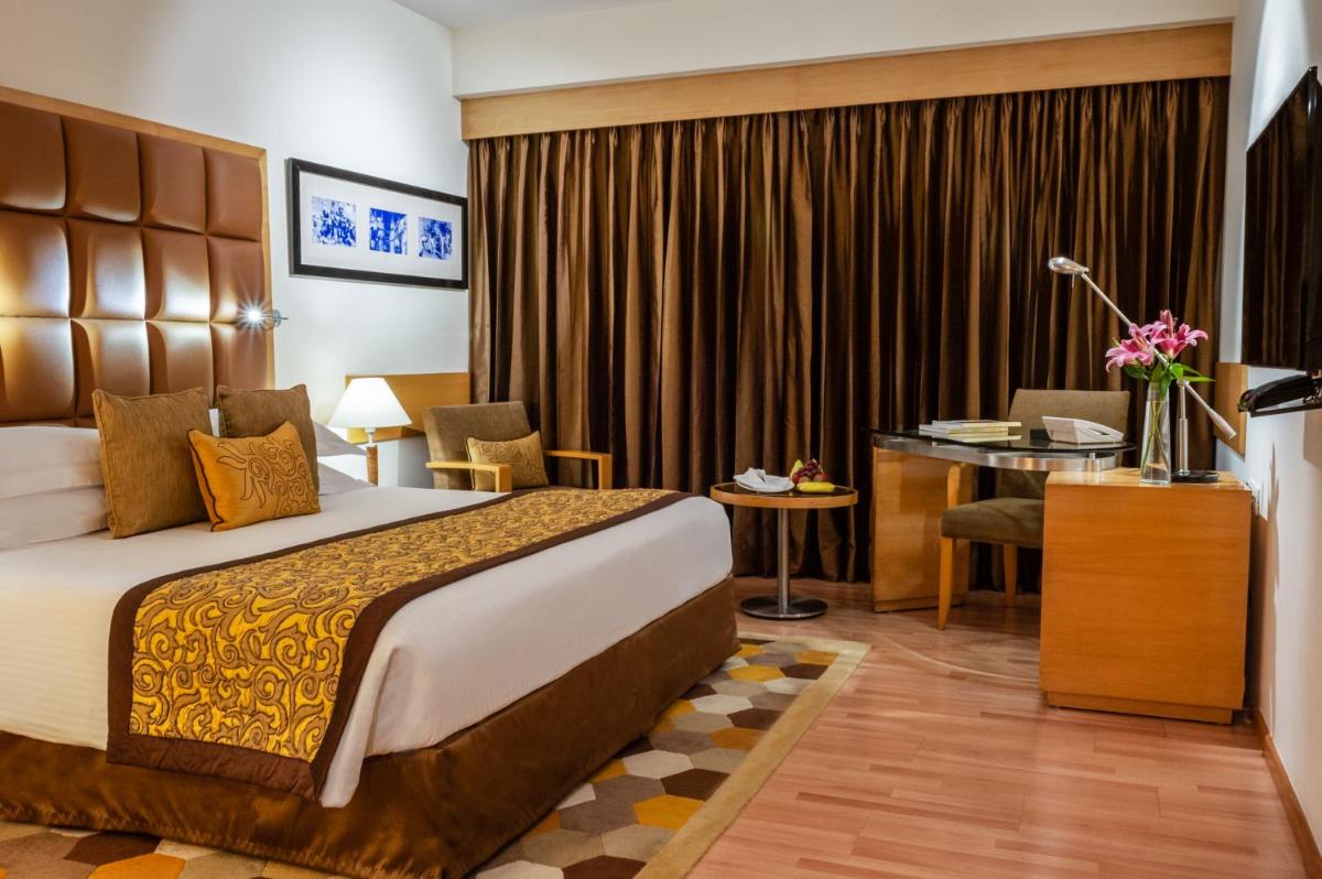 a hotel room with a bed and a desk at Taj Chandigarh in Chandīgarh