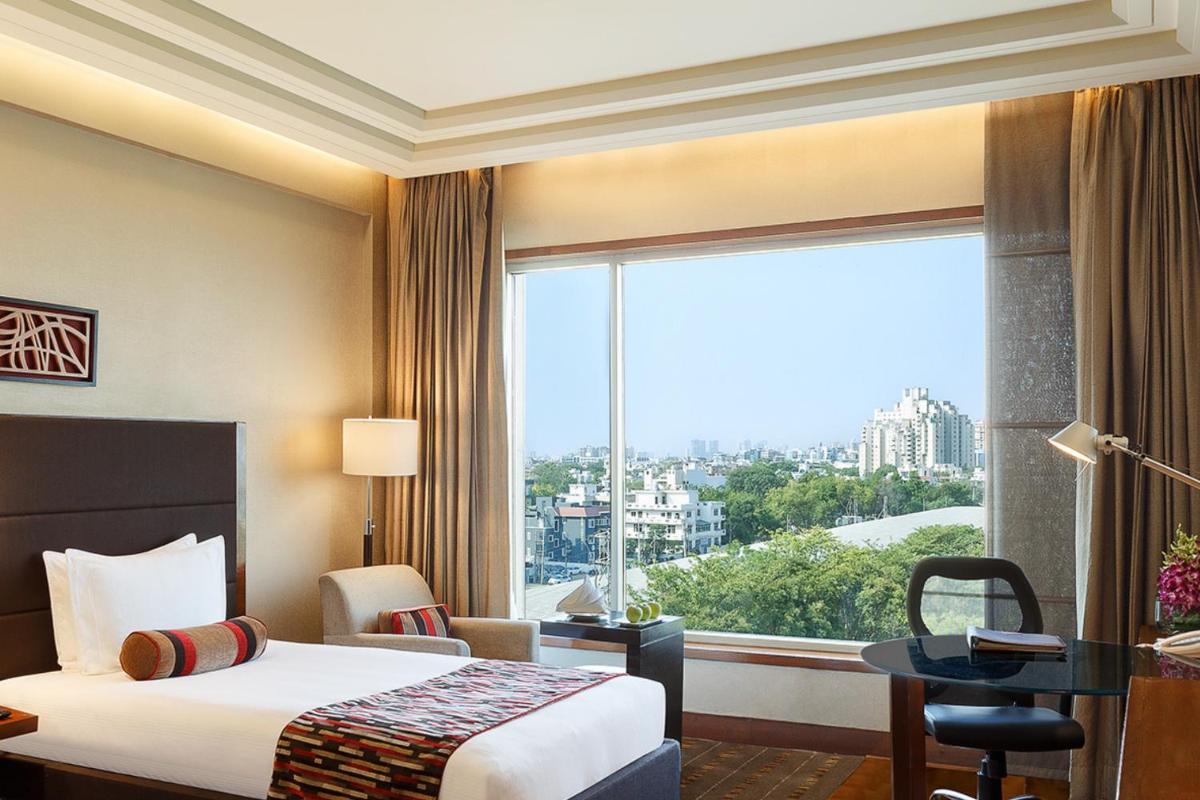 a hotel room with a bed and a large window at Crowne Plaza Today Gurugram by IHG in Gurgaon