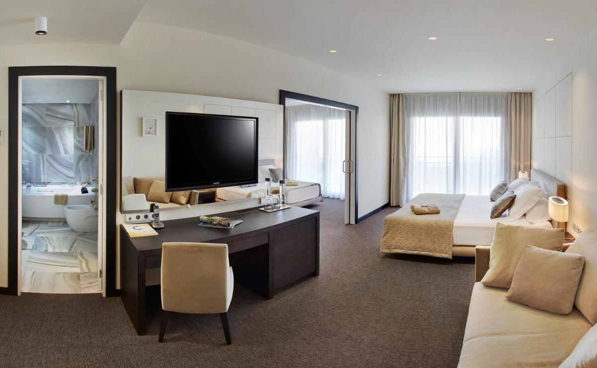 Habitación grande con cama y TV. en Cosmopolita Hotel Boutique & Spa, en Platja d'Aro