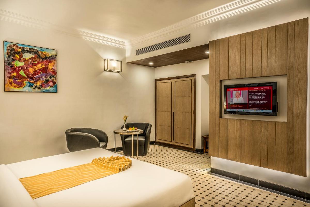 a hotel room with a bed and a tv at Radisson Goa Candolim in Candolim