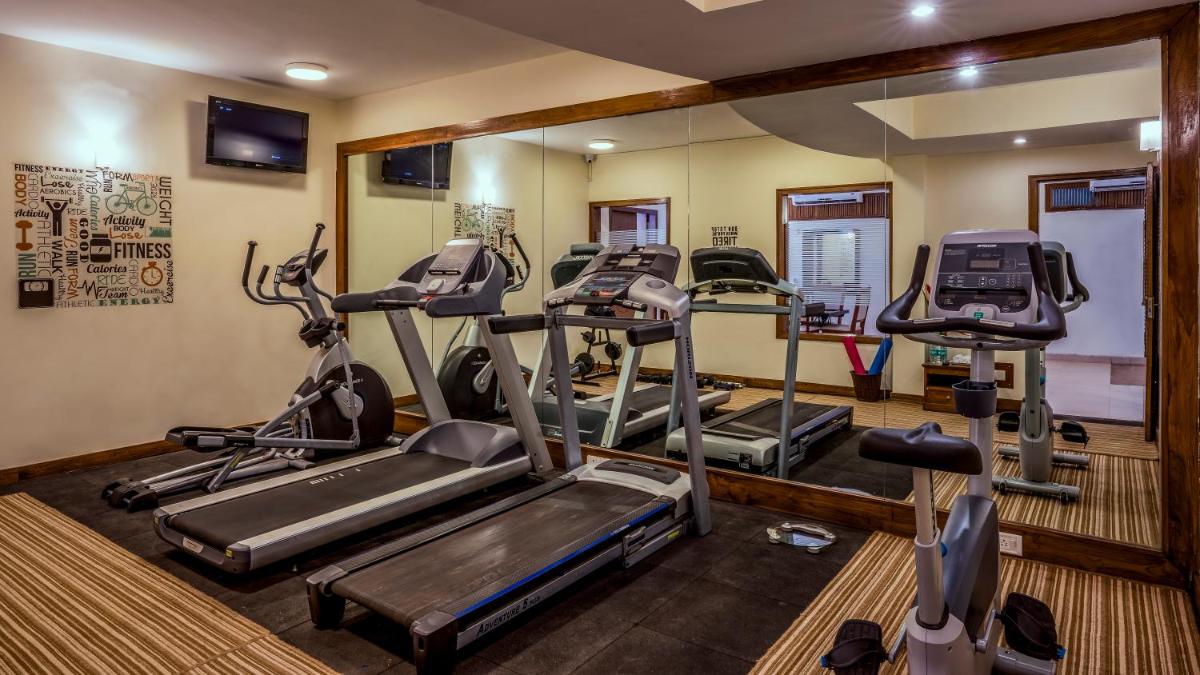 a gym with treadmills and ellipticals in a room at Radisson Goa Candolim in Candolim