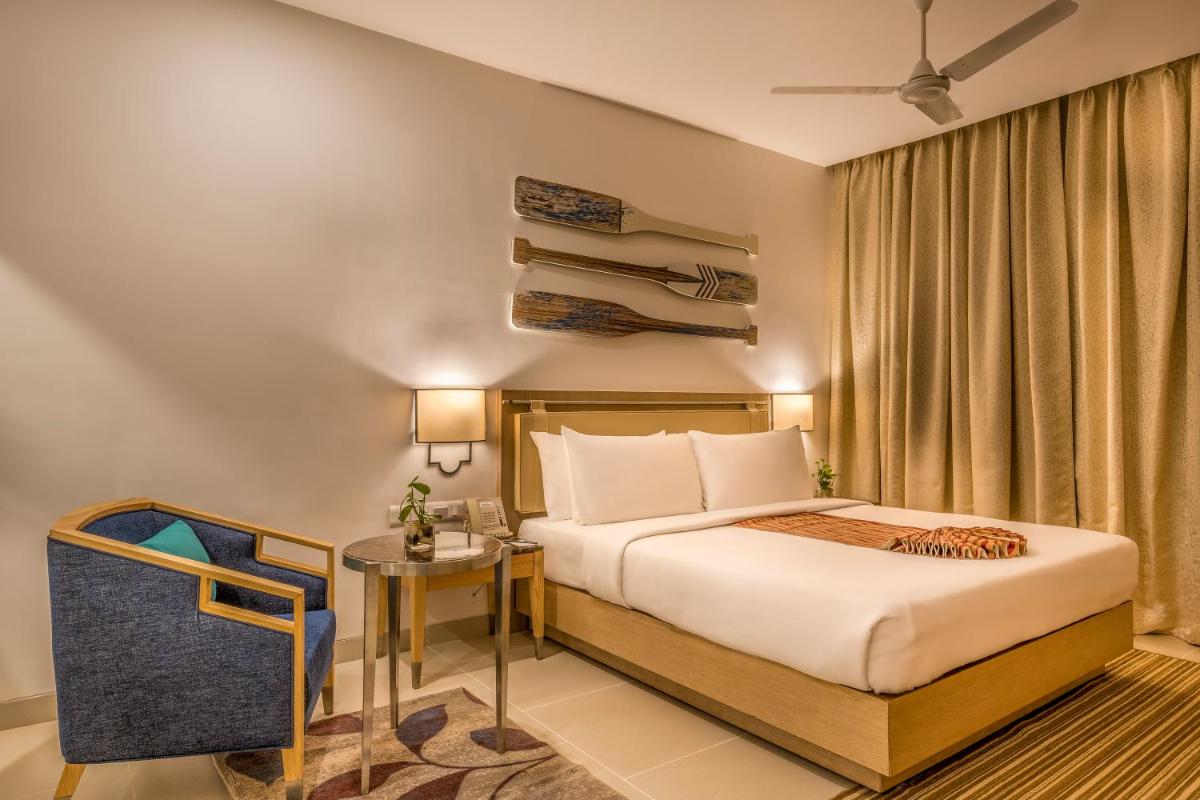 a hotel room with a bed and a table at Radisson Goa Candolim in Candolim