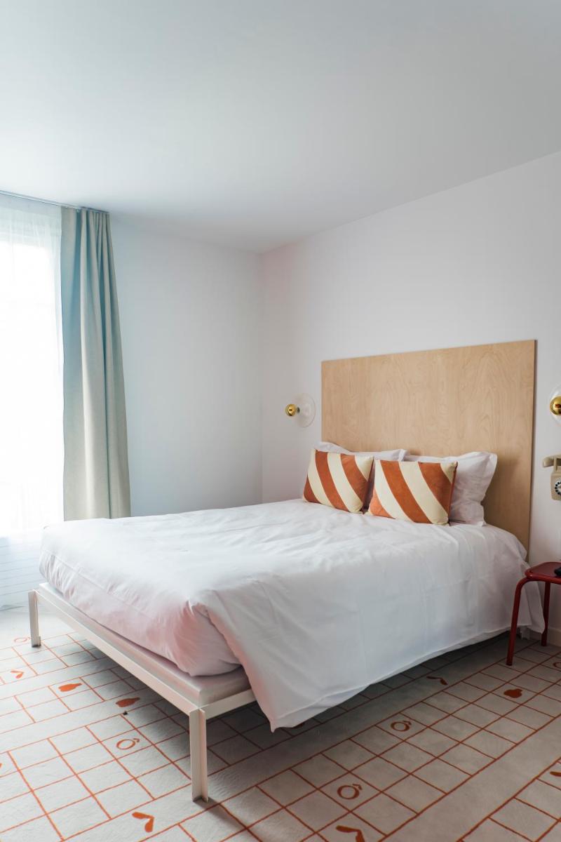 - une chambre dotée d'un grand lit blanc avec des oreillers orange et blancs dans l'établissement Hôtel-Spa Ô Rouge - Gevrey-Chambertin - Teritoria, à Gevrey-Chambertin
