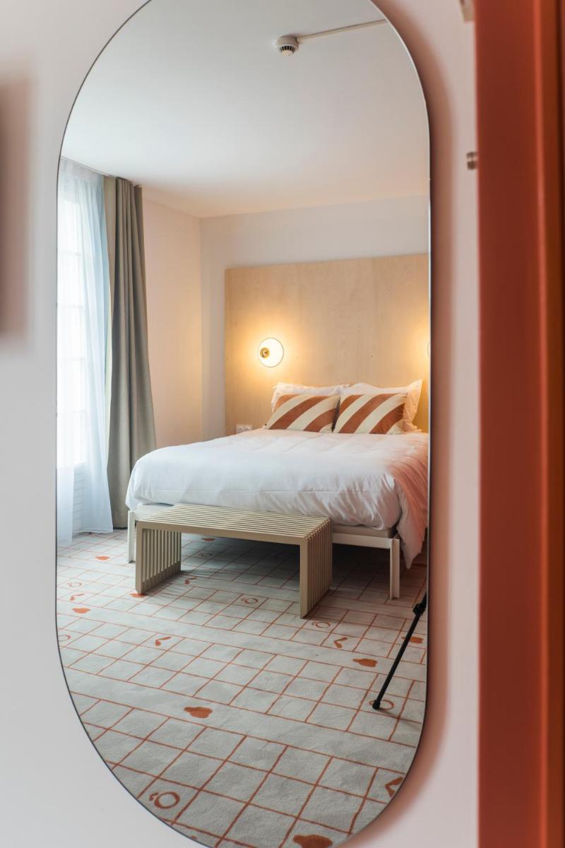 une chambre avec un lit et un miroir dans l'établissement Hôtel-Spa Ô Rouge - Gevrey-Chambertin - Teritoria, à Gevrey-Chambertin