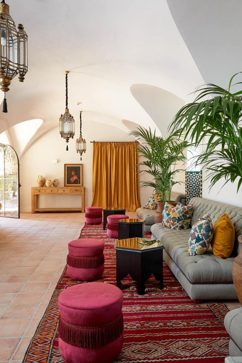 Una sala de estar con un sofá y otomanas rojas. en Soho Boutique Castillo de Santa Catalina - Adults Recommended, en Málaga