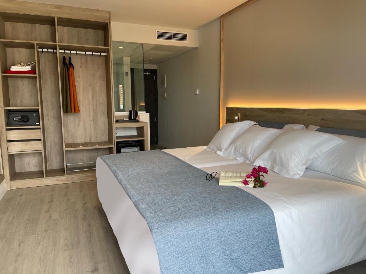 Un dormitorio con una gran cama blanca con flores. en Hotel AF Valle Orotava, en Puerto de la Cruz