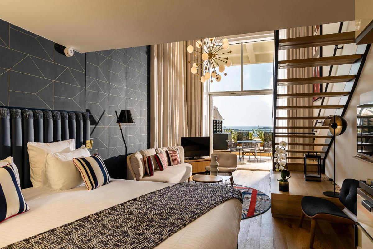 une chambre avec un lit et un salon dans l'établissement Thalazur Saint Jean de Luz - Hôtel & Spa, à Saint-Jean-de-Luz