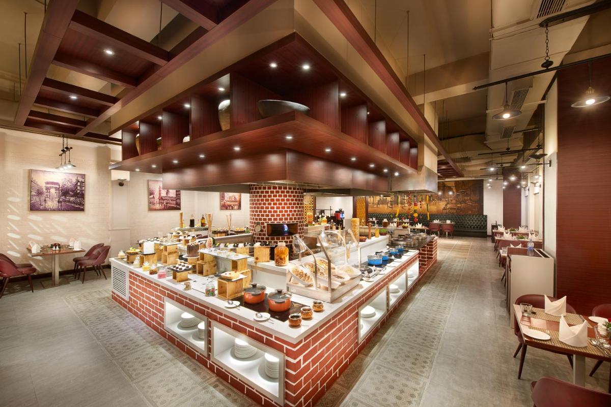 a restaurant with a long counter with food at The Accord Metropolitan in Chennai