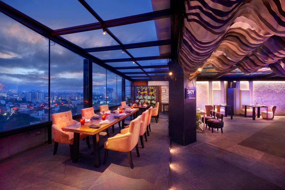 a restaurant with a long table and chairs and a view at The Accord Metropolitan in Chennai