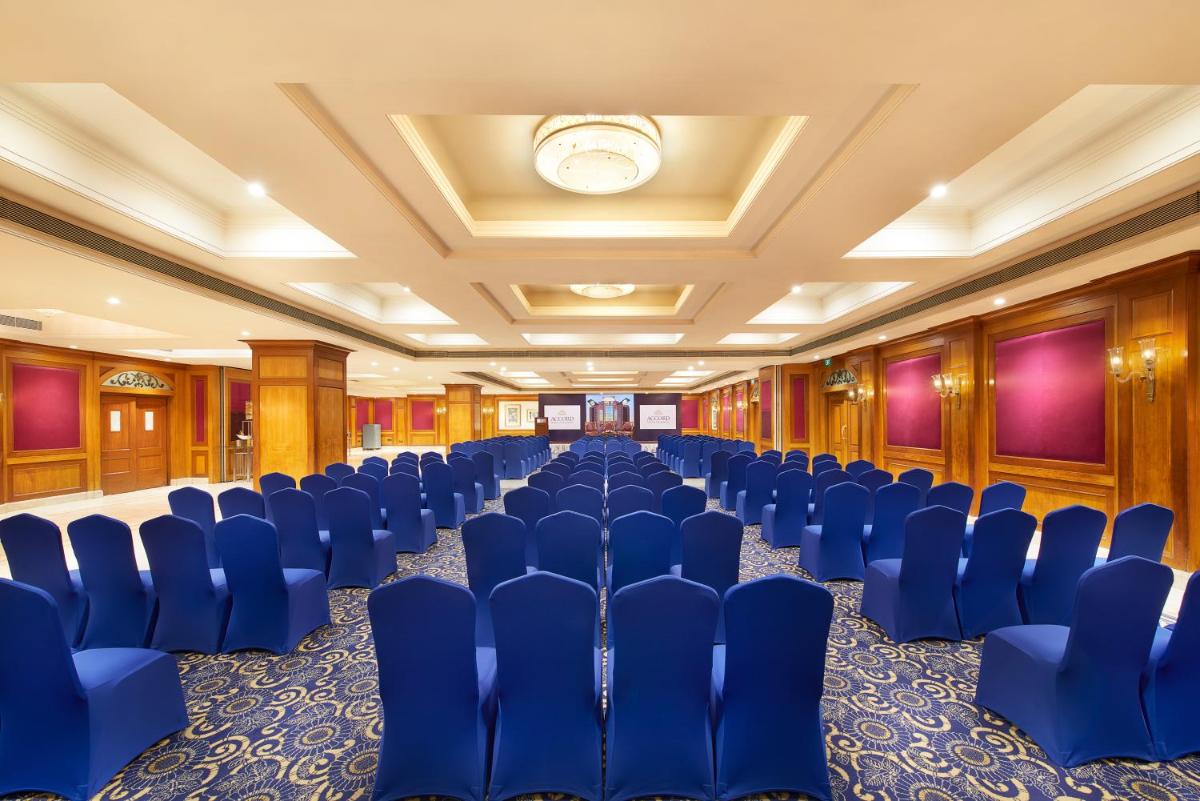 a conference room with blue chairs and a ceiling at The Accord Metropolitan in Chennai
