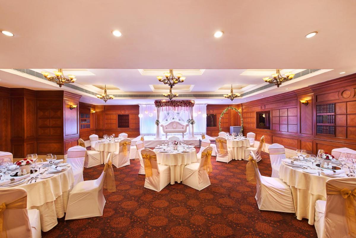 a banquet hall with white tables and chairs at The Accord Metropolitan in Chennai