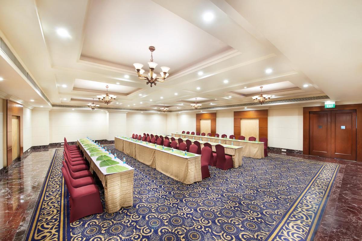a conference room with red chairs and tables in it at The Accord Metropolitan in Chennai