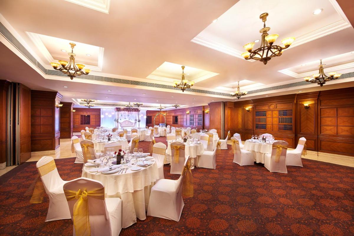 a banquet hall with white tables and chairs at The Accord Metropolitan in Chennai +131 photos