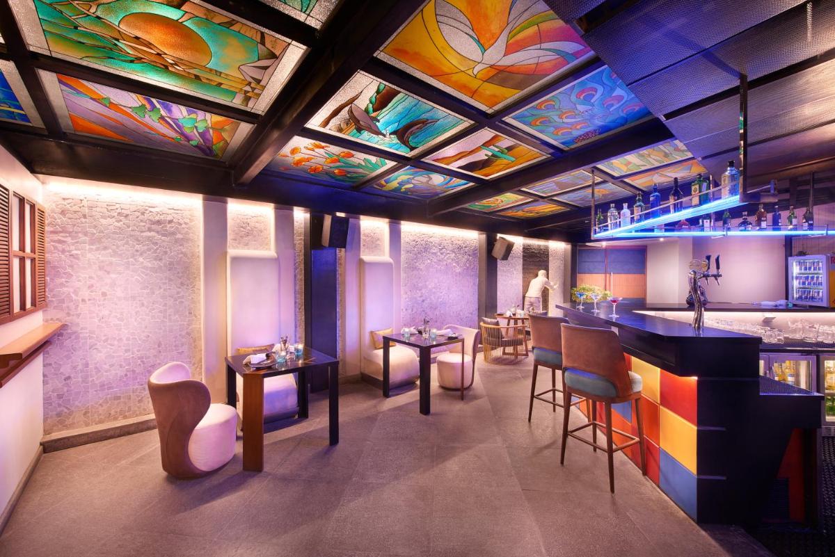 a restaurant with a colorful ceiling and tables and chairs at The Accord Metropolitan in Chennai