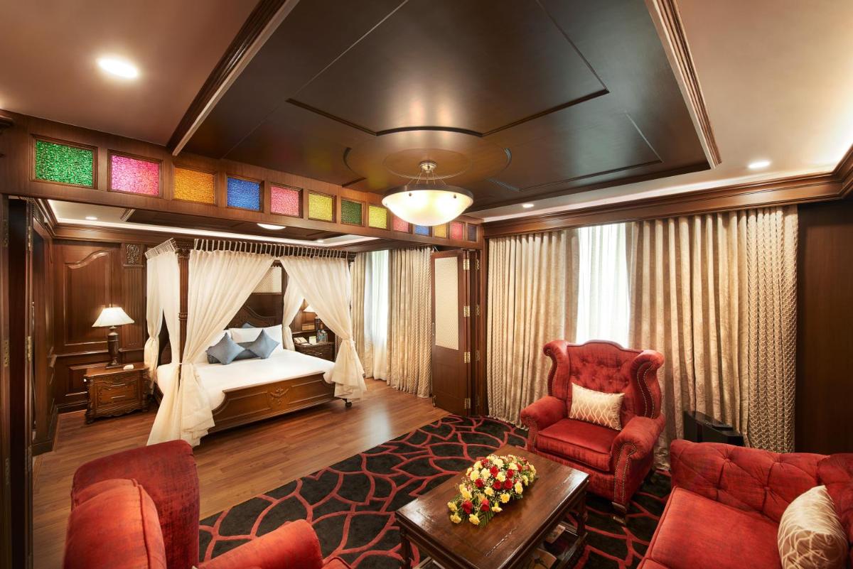 a hotel room with a bed and a red chair at The Accord Metropolitan in Chennai