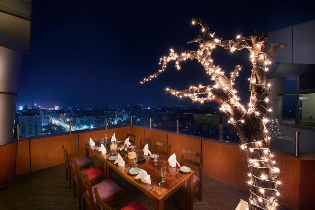 a dining room with a long table with lights at The Accord Metropolitan in Chennai