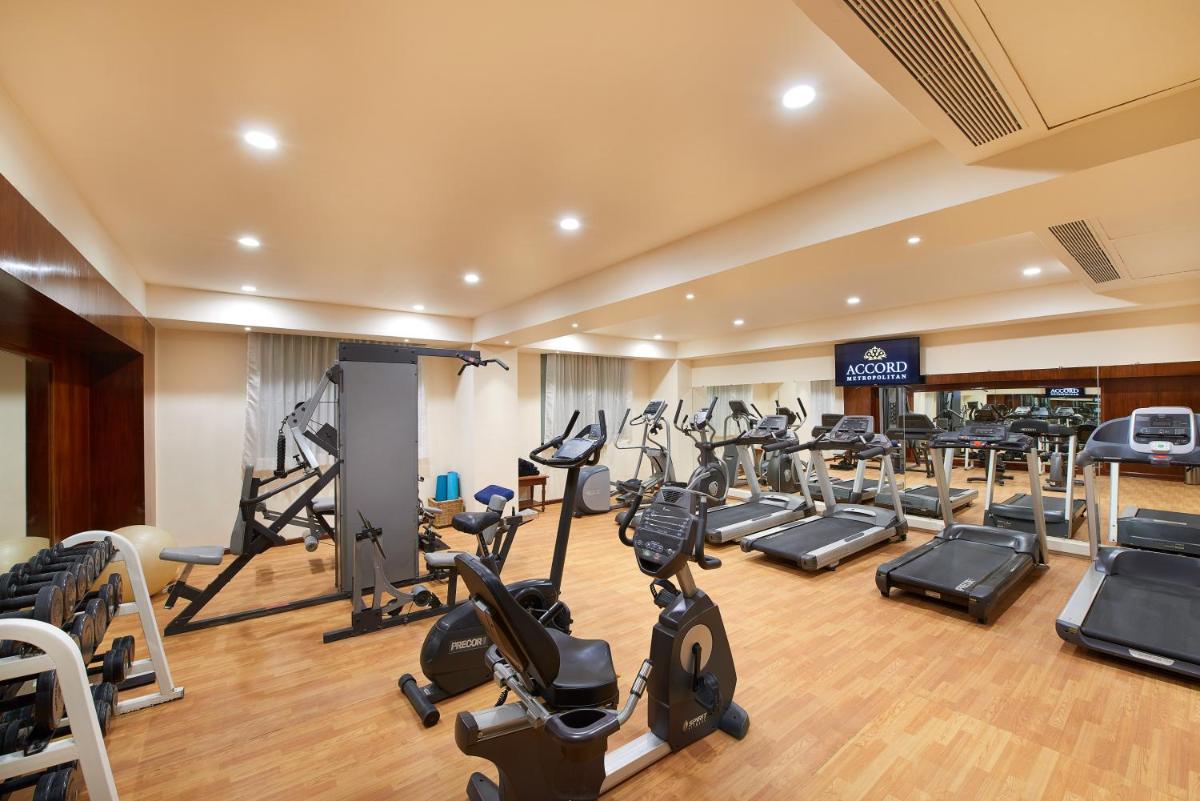 a gym with a lot of treadmills and ellipticals at The Accord Metropolitan in Chennai