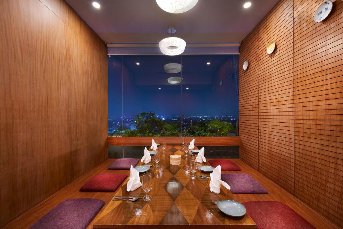 a dining room with a table and a large window at The Accord Metropolitan in Chennai