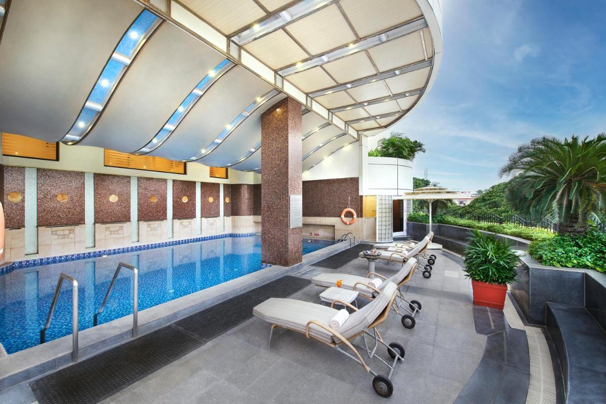 a pool at a hotel with lounge chairs next to it at The Accord Metropolitan in Chennai