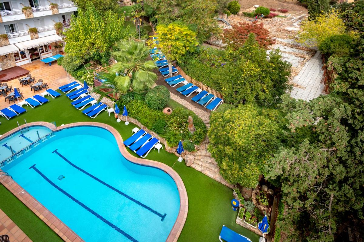 Una vista aérea de una piscina en un complejo turístico. en Hotel GHT Neptuno-Tossa & Venus SPA, en Tossa de Mar